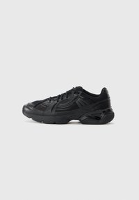 Black athletic sneaker with mesh and leather upper, padded collar, and textured rubber sole shown from the side on a plain background.