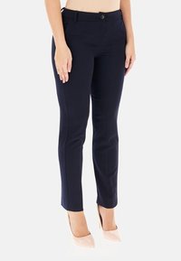 Pantaloni tailored blu navy con vestibilità slim, chiusura a bottone e tessuto leggermente elasticizzato, accentuati da linee pulite e una texture liscia.