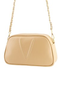 Beige lædertaske med en rund form, der har et fremtrædende præg med "V" design, guldfarvet kædestrop og tekstureret overflade.
