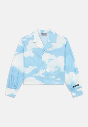 Cropped button-up shirt in blue with cloud pattern, featuring long sleeves with elastic cuffs and a white collar. Logo on cuff.