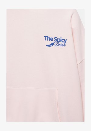 Világos rózsaszín pulóver elején zsebbel és kék szöveggel „The Spicy Drink”, amelyet csilipaprika grafika díszít a mellrészen.