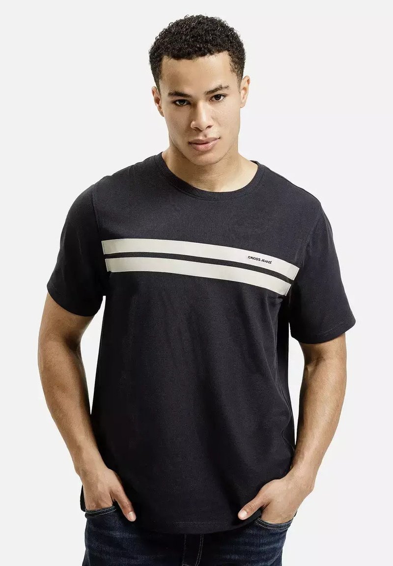 Czarna bawełniana koszulka z dwoma ukośnymi, beżowymi paskami na klatce piersiowej. Okrągły dekolt i krótkie rękawy. Minimalistyczny design.