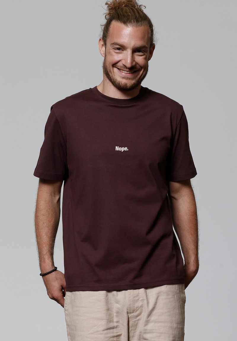 Bordeaux katoenen t-shirt met korte mouwen, waarop de tekst "Nee." in het wit op de borst is gedrukt. Eenvoudig, relaxed fit ontwerp.