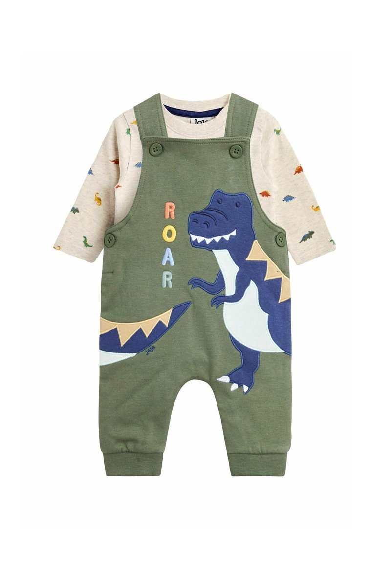 Grüner Overall mit einem verspielten Dinosaurierdesign und gesticktem "ROAR"-Text, kombiniert mit einem beigen Langarmshirt mit bunten Dinosauriermustern.