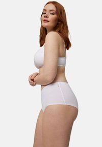 Bralette blanco y braguitas a juego de cintura alta hechas de un tejido suave y transpirable. Diseño sin costuras con costuras delicadas y una textura sutil.