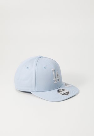 Cappellino da baseball azzurro chiaro con visiera piatta, caratterizzato da un logo "LA" ricamato in bianco, occhielli cuciti e un'etichetta sul lato inferiore della visiera.