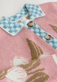 Džemper na pletenje s ružičastim tijelom, plavim kariranim okovratnikom i cvjetnim uzorcima u nijansama ružičaste i smeđe, s dva smeđa gumba.
