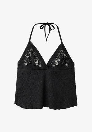 Haut dos nu noir en tissu texturé avec broderie florale en sequins argentés sur la poitrine, avec fermeture à nouer au cou.