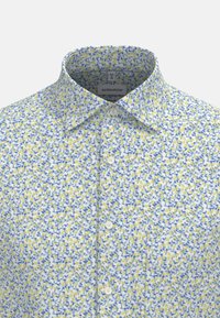 Lichte katoenen blouse met een witte basis, voorzien van een bloemenpatroon in blauw en geel. Met een klassieke kraag en vier knopen.