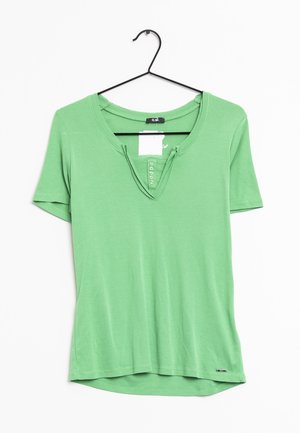 Groene T-shirt met korte mouwen van zacht katoen, met een ronde halslijn en een vijfknopenlijst. De onderkant is licht gebogen.