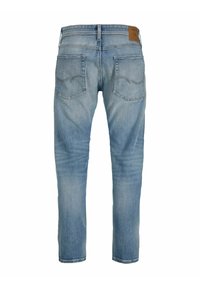 Jeans de mezclilla de color azul claro mostrados desde atrás, con dos bolsillos cosidos y una etiqueta de marca de cuero marrón en la cinturilla.