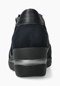 Chaussure en suède bleu foncé avec un accent en cuir noir lisse au niveau du talon, présentant une forme arrondie et une semelle noire texturée et basse.