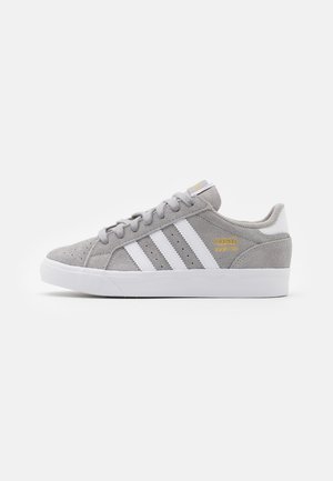 Grey suede Adidas low-top sneaker with white stripes, white sole, laces, and gold Adidas branding on the side.