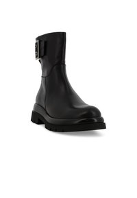 Stivale alla caviglia in pelle nera con suola spessa, dotato di una cinghia laterale con elementi in metallo argentato e una finitura liscia e testurizzata.