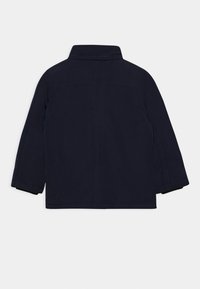 Chaqueta azul marino con cuello, mangas largas, corte recto, costura trasera sencilla y detalles de costura sutiles.