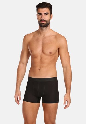 Zwarte boxershorts met een zachte, elastische tailleband en een slimfit ontwerp, gemaakt van een gladde, rekbare stof. Minimale stikseldetails.