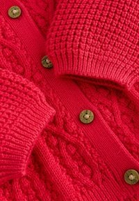 Rød strikket cardigan med kabler, ribbede manchetter og brune knapper med "NEXT" indgravering.