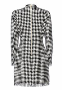 Płaszcz w czarno-biały wzór pepitki z wysokim kołnierzem, długimi rękawami i frędzlami na dole. Posiada niewidoczny zamek błyskawiczny z tyłu na środku.