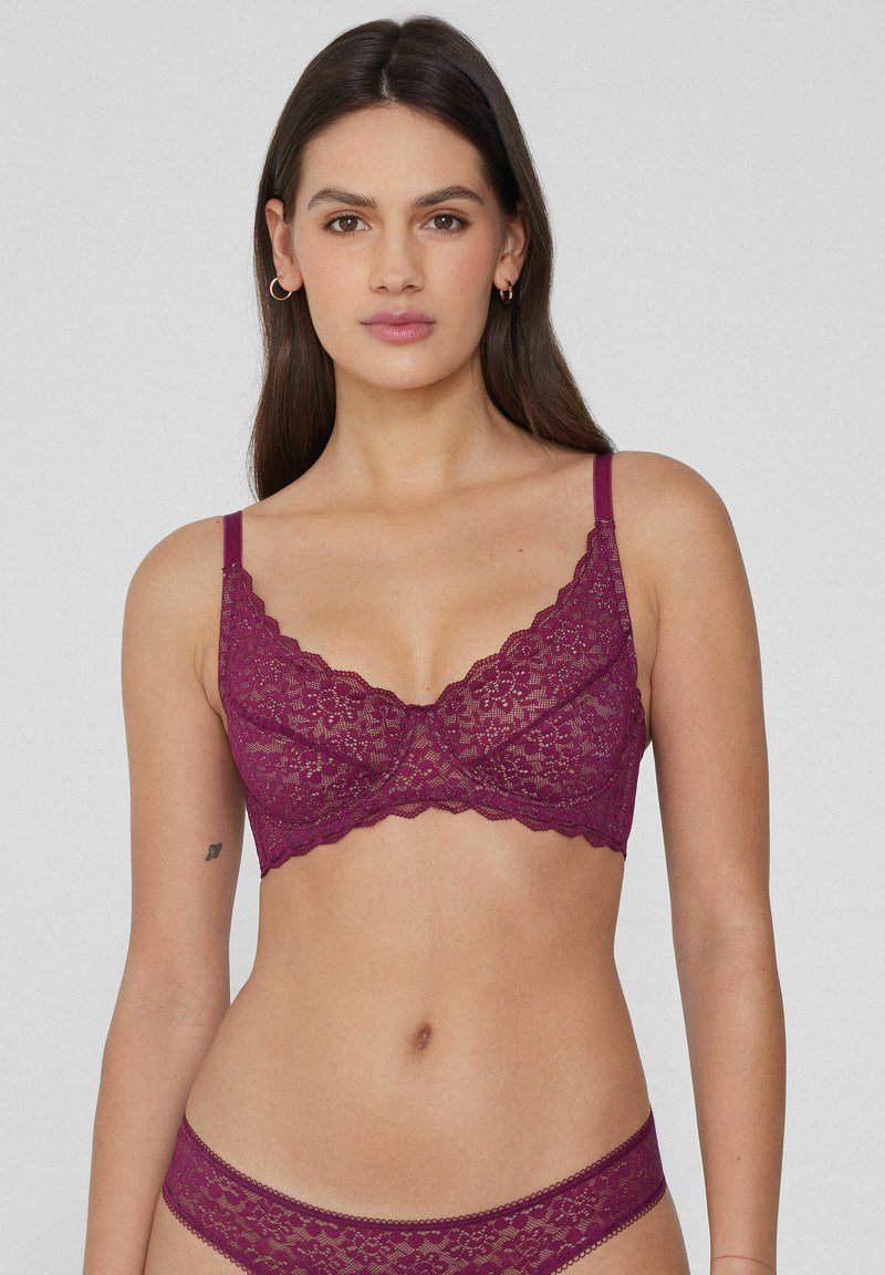 Lace bralette in deep burgundy with scalloped edges, adjustable straps, floral pattern, and soft texture. Matching lace underwear included.