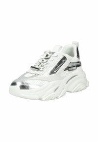 Scarpa da ginnastica chunky bianca e argento con suola spessa, chiusura frontale con lacci e marchio "Steve Madden" sul lato.