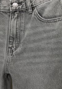 Grijze denim jeans met een textuurafwerking, voorzien van een voorzak, vervaagde plekken en een metalen knoopsluiting bij de tailleband.