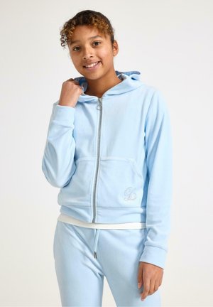 Felpa con zip di colore azzurro chiaro in tessuto morbido, con tasche frontali, cappuccio regolabile con coulisse e dettaglio del logo ricamato. Abbinata a un completo da casa coordinato.