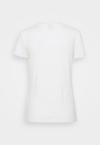 Bílý žebrovaný tričko s krátkými, zubatými rukávy a kulatým výstřihem. Hladká textura, úzký střih a žádné viditelné značky ani vzory.