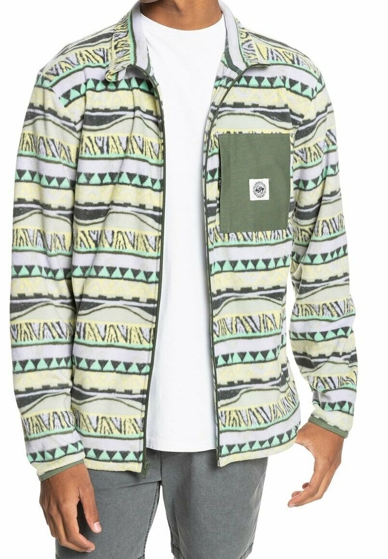 Chaqueta de forro polar con un patrón tribal multicolor en verde, amarillo y gris. Incluye un bolsillo de parche verde y un cierre totalmente de cremallera.