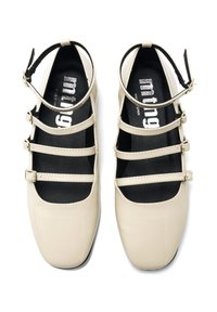 Chaussures en cuir verni beige à bout arrondi, dotées de plusieurs sangles ajustables à l'avant et d'une finition lisse et brillante.