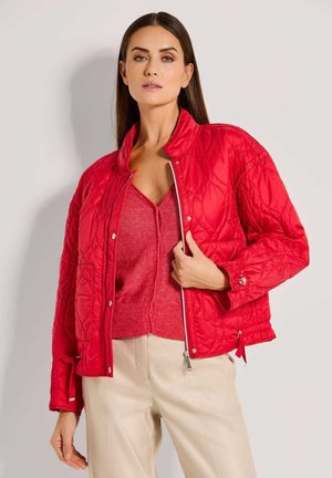 Rote gesteppte Jacke mit hohem Kragen und Reißverschluss. Sie verfügt über einen strukturierten Stoff, seitliche Taschen und verstellbare Ärmel. Wird mit einem passenden Oberteil kombiniert.