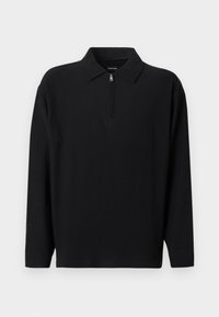 Μαύρο μακρυμάνικο πόλο φούτερ με φερμουάρ στον γιακά. Ριμπ ύφανση, άνετη γραμμή και χωρίς εμφανή λογότυπα ή σχέδια.