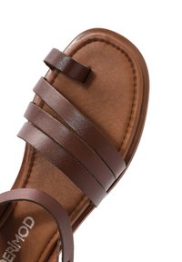 Sandalo in pelle marrone con tre cinturini superiori e una soletta testurizzata. Design della punta arrotondata. Presenta una suola marrone chiaro.