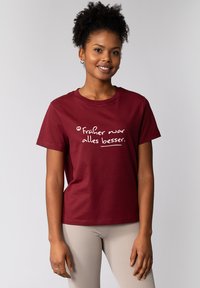 Weinrote Baumwoll-T-Shirt mit weißem Aufdruck, der "Früher war alles besser." sagt. Kurze Ärmel und klassischer Rundhalsausschnitt.