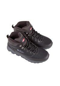 Scarpe da trekking nere con tomaia testurizzata, chiusura con lacci e collo imbottito. Presentano una suola robusta e un marchio sul lato.