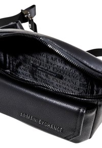 Borsa nera in pelle con una superficie testurizzata, apertura con zip e interno stampato con il logo Armani Exchange.