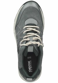 Zapatilla de ante gris con un cuello y una lengüeta acolchados, cordones gris claro y una suela de goma oscura; incluye detalles de malla para mayor transpirabilidad.