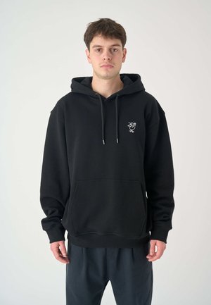 Black hoodie with a kangaroo pocket, drawstring hood, and a small embroidered design on the chest. Fabric appears soft and smooth.