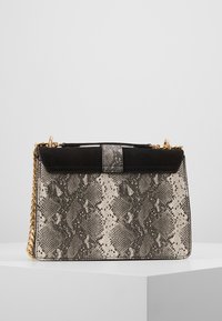 Strukturovaná kabelka s černým semišem nahoře, tělem s hadím potiskem v béžových a šedivých tónech a zlatým řetízkovým popruhem.