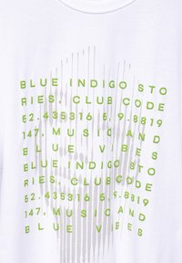 Bílý tričko s jasně zeleným textem a grafickými prvky, včetně čísel a písmen uspořádaných ve vertikálním vzoru.