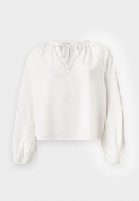 Blusa blanca de manga larga con puños elásticos y escote en V con un pequeño detalle de lazo en el cuello.