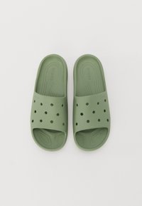 Sandali in gomma verde con design perforato sulla fascetta, suola testurizzata e bordi arrotondati, offrendo uno stile casual e traspirante.