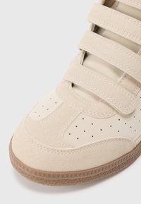 Μπεζ αθλητικά παπούτσια με σουέτ και λείο δέρμα, με ριγέ λωρίδες από βέλκρο, τρυπητές λεπτομέρειες και υφασμένο καουτσούκ σόλα.