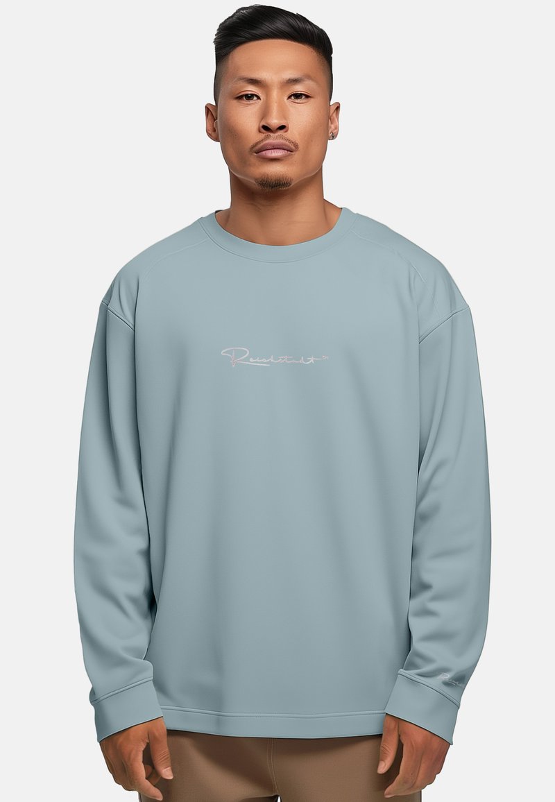 Felpa azzurro chiaro con scollatura a girocollo, maniche lunghe e un logo sottile in rosa. Tessuto morbido con una consistenza liscia.