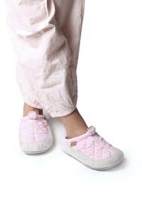 Rosa vadderade tofflor med ett mjukt vitt fleecefoder och gummisulor; har en dekorativ knapp och en subtil textur.