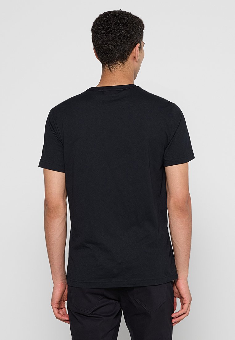 Czarny bawełniany T-shirt z okrągłym dekoltem, krótkim rękawem i luźnym krojem, o gładkiej fakturze, bez widocznych wzorów ani ozdób.