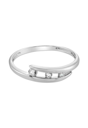 Bague en argent avec trois pierres précieuses rondes et transparentes, posée sur une bande moderne légèrement courbée avec des espaces ouverts entre les pierres.