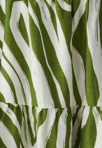 Roheline ja valge sebrarihmastusega kangas, millel on tekstuuriga tegelik linane välimus; sisaldab laines jooni ja kokkutõmmatud kihte.