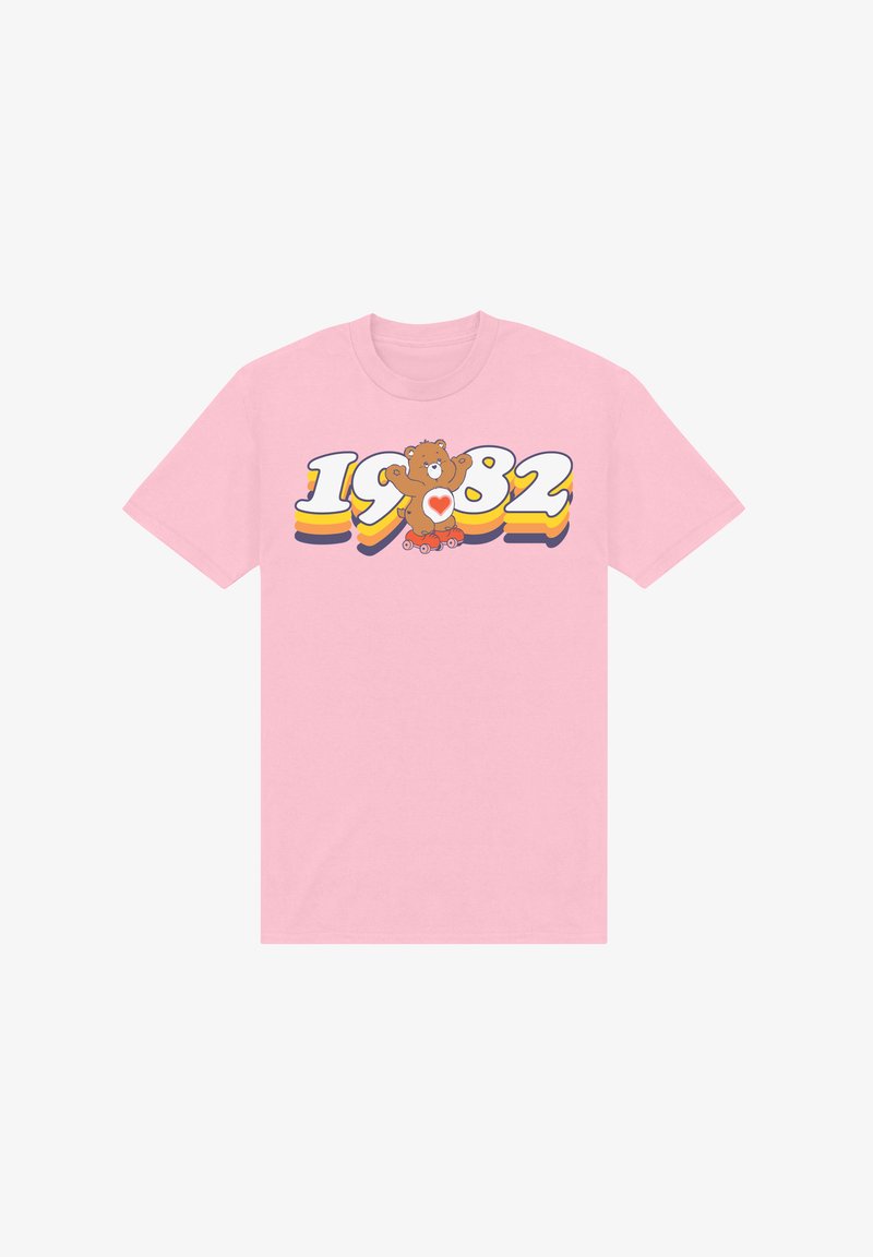 Roze katoenen t-shirt met een grafisch ontwerp van een teddybeer en de tekst "1982" in levendige kleuren en een speelse stijl. Korte mouwen en een ronde hals.