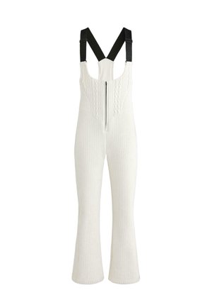 Bele pletene kombinezone z zadrgo spredaj, nastavljivimi črnimi naramnicami, rebrasto teksturo in razširjenimi hlačnimi nogavicami.