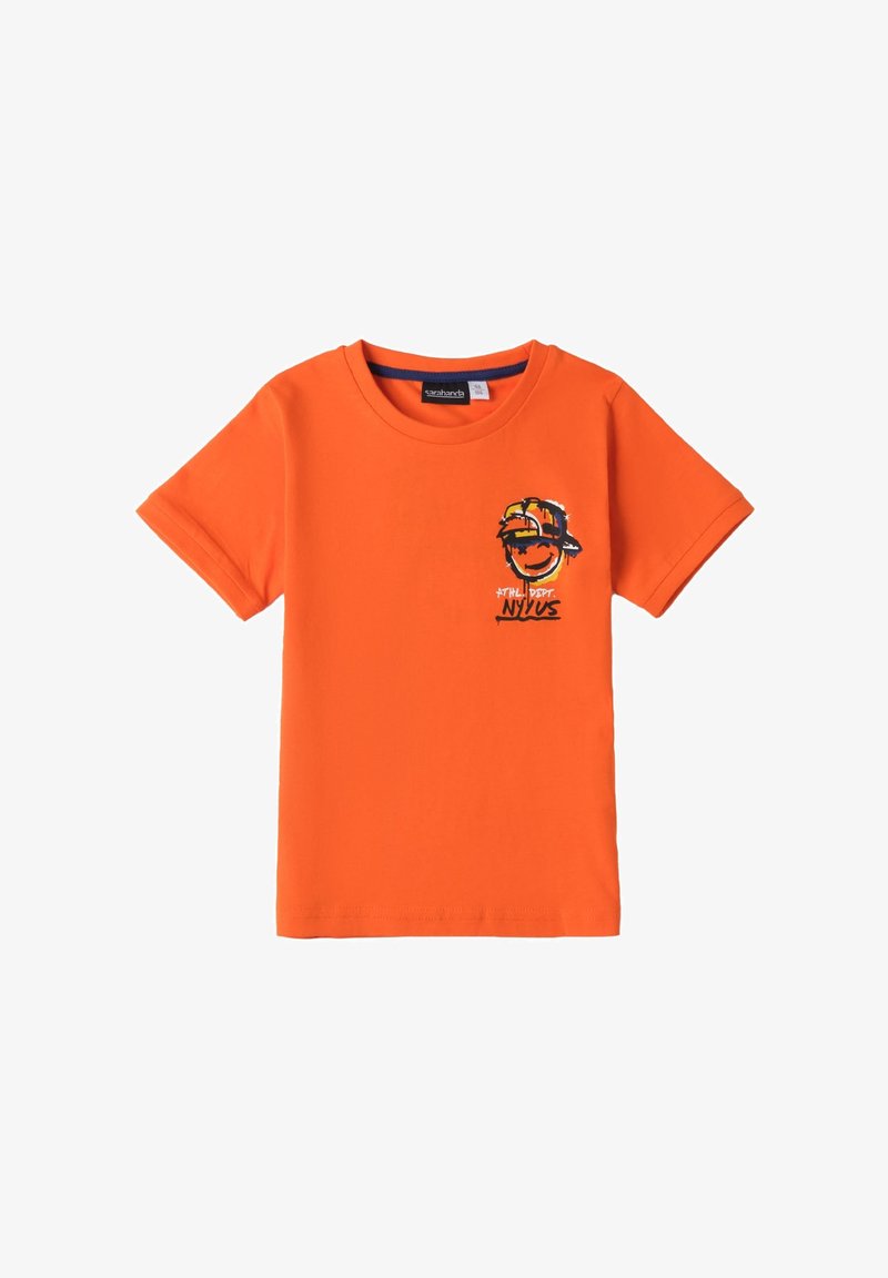 Camiseta de manga corta naranja hecha de algodón, con un gráfico de una cara sonriente con gorra y el texto "NYUS" en el lado izquierdo del pecho.